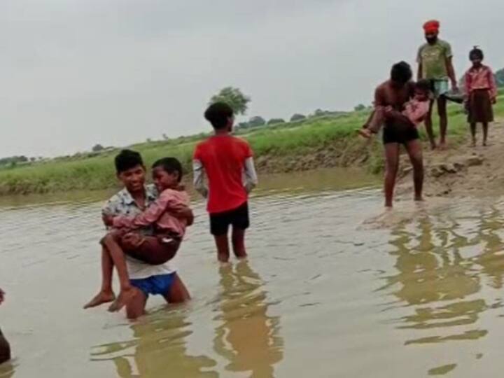 UP Flood Hardoi Bridge washed away due to flood contact of many villages lost Rajbaha carrying children in his lap to cross ANN UP Flood: हरदोई में बाढ़ से बह गई पुलिया, कई गांवों का संपर्क टूटा, बच्चों को गोद में उठाकर पार करा रहे रजबहा