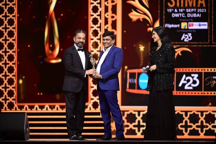 As she gave an award on stage, Shruti Haasan wore a shimmering black jacket with a black saree.