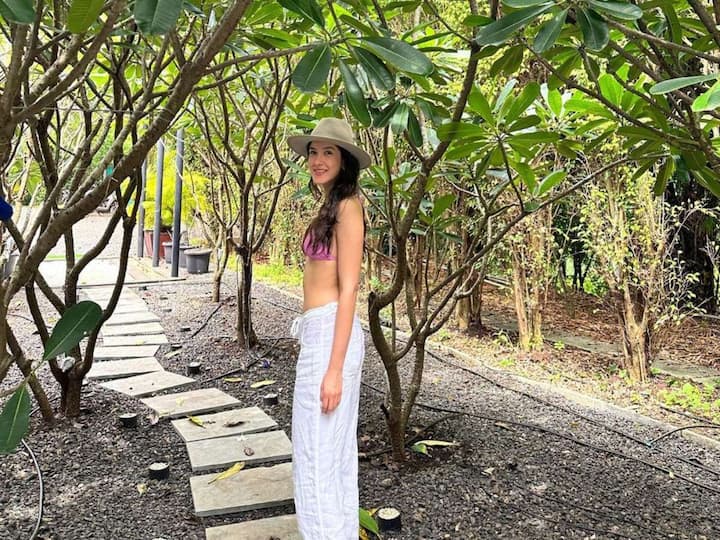 Shanaya Kapoor's most recent outfit, which has a pink bikini top, flared pants, and a stylish cap, is perfect for a beach day.