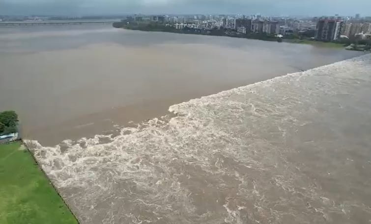 Surat Tapi River: latest photos of overflow of tapi river, in between ukai dam water speed in surat Tapi River: ઉકાઇમાંથી ધડાધડ પાણી છોડાતા તાપીએ ધારણ કર્યુ રૌદ્ર સ્વરૂપ, જુઓ બે કાંઠે થયેલી નદીની તસવીરો....