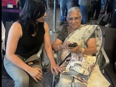 రద్దీగా ఉండే విమానాశ్రయంలో ప్రయాణికులతో సుధా మూర్తి మాటామంతీ