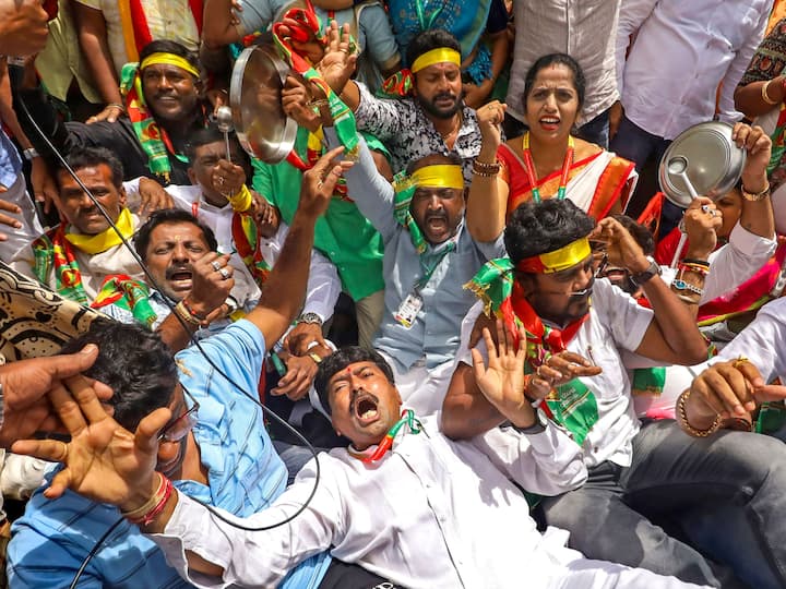 People stage a protest during a 'bandh' called by farmers and Kannada organisations. Officegoers had a harrowing time at the IT hub as bus services were partially hit. (Image Source: PTI)