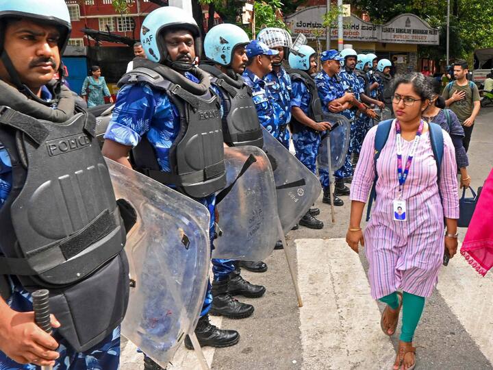 Rapid Action Force (RAF) personnel stand guard during a 'bandh'. Bus services from Tamil Nadu towards Karnataka were disrupted. Several buses from Tamil Nadu were stopped at Zuzuvadi in Krishnagiri district, ANI reported. KSRTC buses and autorickshaws remained off the roads. (Image Source: PTI)