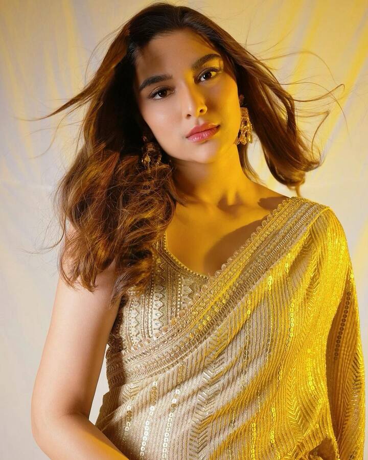 Saiee turns up the glam quotient in a dazzling golden sequin saree. With this look, she epitomizes sheer Bollywood glamour, and her choice of saree is a testament to her fashion-forward choices. (Image Source: Instagram/ Saiee M Manjrekar)