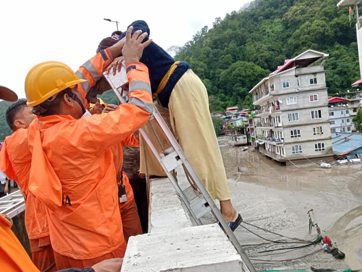NDRF personnel rescue a woman from a flood-affected area in north Sikkim. (Source: ANI)