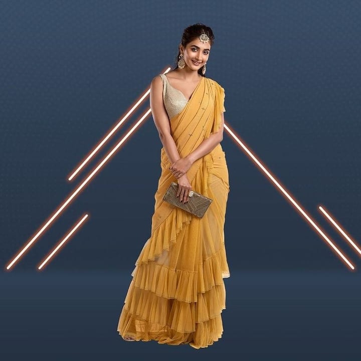 Pooja Hedge turned heads with her mustard yellow ruffle saree, paired with a gold blouse and a matching gold clutch. The combination exuded classic charm with a modern twist. (Image Source: PR Handout)
