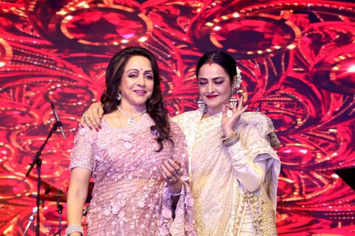 Rekha and Hema Malini share a candid moment on the stage.