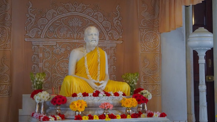 বেলুড় মঠ প্রতিষ্ঠার আগে থেকেই স্বামী বিবেকানন্দের মনে ইচ্ছে ছিল যে তিনি বেলুড়মঠে দুর্গাপুজো করবেন। ১৮৯৭ খ্রিস্টাব্দে বেলুড়মঠ প্রতিষ্ঠার পর স্বামীজী প্রায়ই তাঁর প্রিয় বেলগাছতলায় বসে সম্মুখে প্রবাহিতা গঙ্গার দিকে তাকিয়ে আপন মনে গাইতেন, “বিল্ববৃক্ষমুলে পাতিয়া বোধন/গণেশের কল্যাণে গৌরীর আগমন।/ঘরে আনব চণ্ডী, কর্ণে শুনব চণ্ডী,/আসবে কত দণ্ডী, জটাজুটধারী।…” আজ স্বামীজির করা সেই দুর্গোৎসব এক মহীরুহে রূপান্তরিত হয়েছে। সারা পৃথিবী থেকে ভক্তেরা আসেন এই মহোৎসবে সামিল হতে। ছবিসূত্র- রামকৃষ্ণ মঠ এবং রামকৃষ্ণ মিশন, বেলুড় মঠ/ ফেসবুক