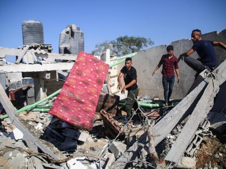 Palestinian emergency services and local citizens search for victims in buildings destroyed during Israeli air raids in the southern Gaza Strip. (Photo: Getty)