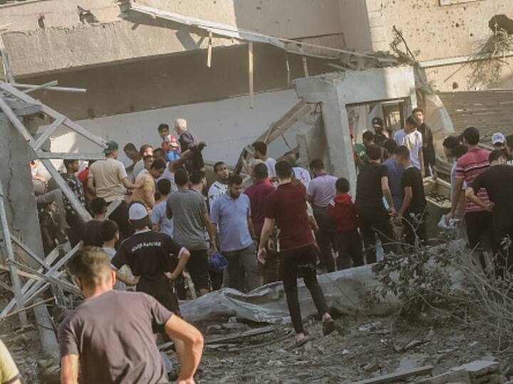 The rescue team and local residents work together to recover a deceased body from beneath the rubble in buildings that were demolished by Israeli airstrikes. (Photo: Getty)