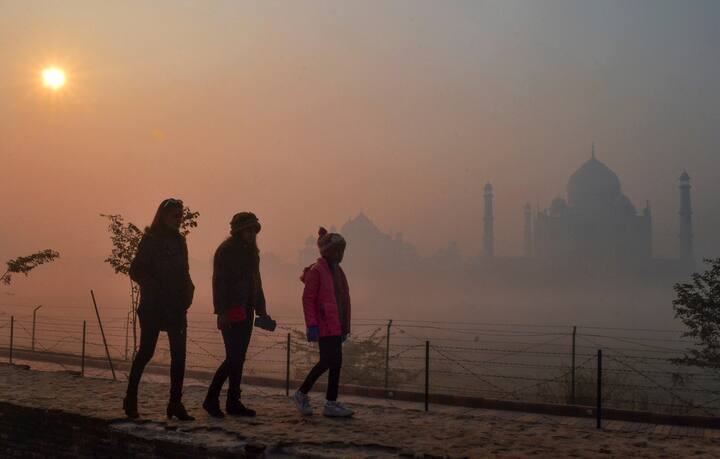 कडाक्याच्या थंडीत दाट धुक्यात हरवलेल्या ताजमहालाचे फोटो घेण्याचा मोह पर्यटकांना आवरत नसल्याचं पाहायला मिळत आहे.  (Photo Credit : PTI)