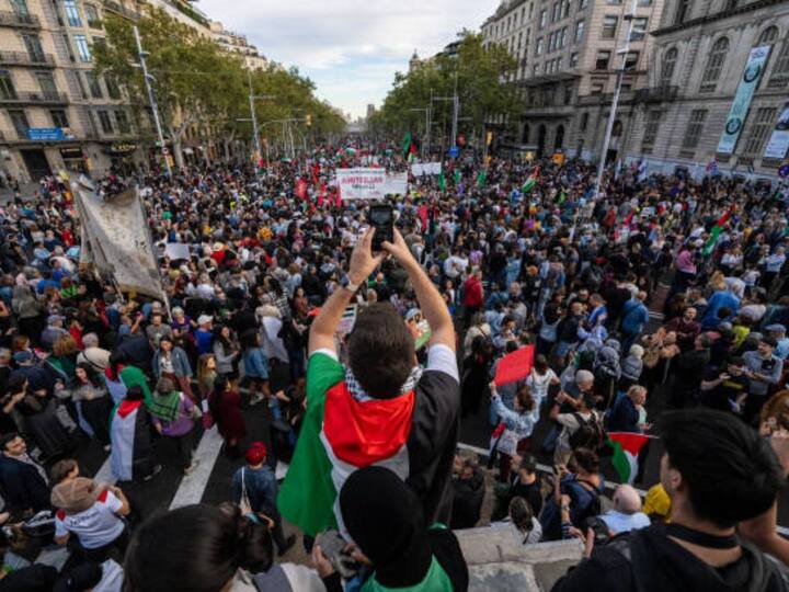 A man takes a photo of protesters during a pro-Palestinian rally on Saturday in Barcelona, Spain. There has been an escalation in pro-Palestinian demonstrations worldwide, following the October 17 explosion at the Al-Ahli al-Arabi Hospital in the Gaza Strip. (Image Credit: Getty Images)