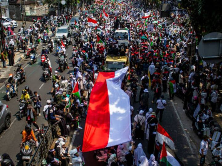 Protesters shout slogans and hold palestine flags during a rally in solidarity with the Palestinian people on October 21, 2023 in Bandung, Indonesia. (Image Credit: Getty Images)