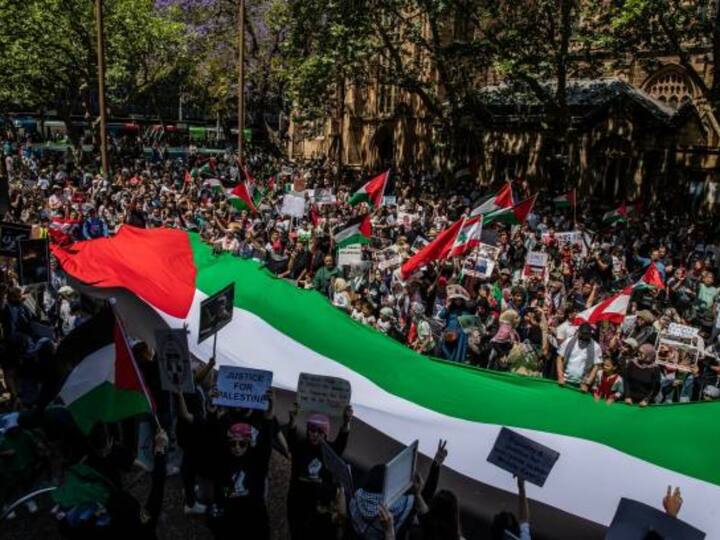 Pro-Palestinian hold a giant Palestinian flag during a protest at Town Hall in Sydney, Australia. Israeli launched counter-offensive on Gaza after Hamas' October 7 surprise attack on Israel. (Photo by Roni Bintang/Getty Images)