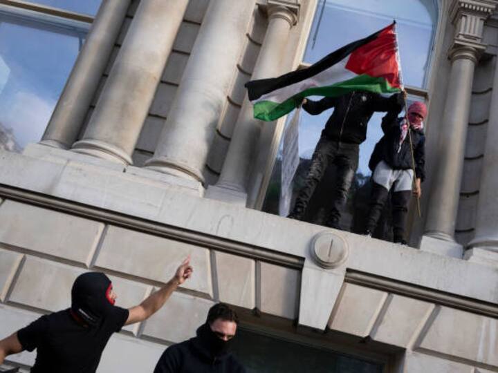 Protesters stand on the ledges of British government buildings in Whitehall as Pro-Palestinians march through central London for the second consecutive week after the attacks by Hamas on Israel. (Image Credit: Getty Images)
