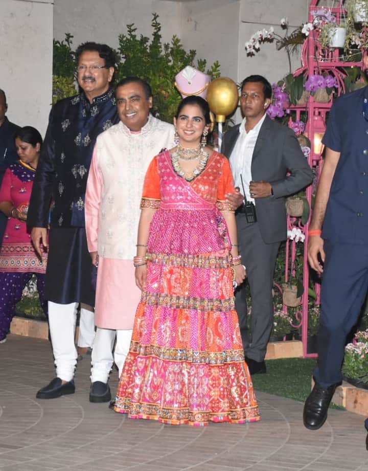 इस खास मौके के लिए ईशा ने पिकं एंड ऑरेंज कलर की राजस्थानी स्टाइल की फ्रॉक पहनी थी. फ्रॉक पर बांधनी वर्क हो रखा था.साथ में ईशा ने हैवी ज्वैलिरी कैरी की थी.वहीं मुकेश अंबानी ने पिक एंड व्हाइट कलर का कुर्ता पायजामा पहना था जिसके साथ उन्होंने ऑफ व्हाइट कलर की जैकेट कैरी की थी.