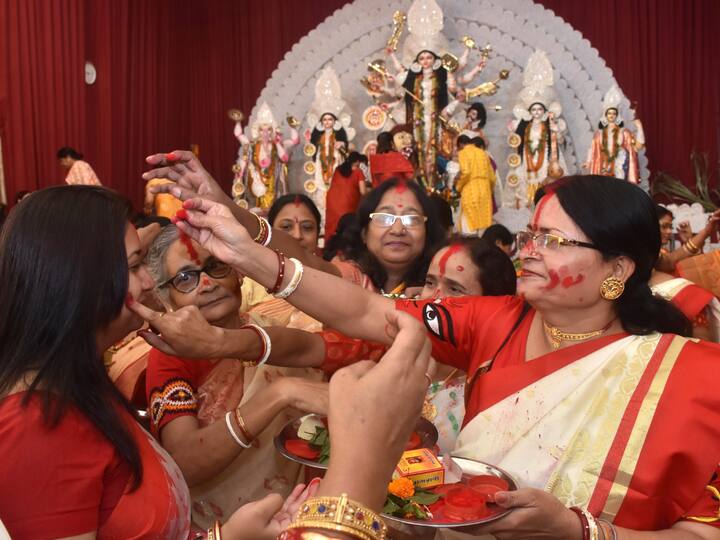 Women apply vermillion on each other as they participate in 'Sindoor Khela' on 'Vijayadashami', the last day of Durga Puja festival celebrations, in Ranchi. Image Source: PTI