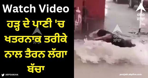 child started swimming in flood water on road watch viral video Viral Video: ਸੜਕ 'ਤੇ ਤੇਜ਼ ਵਹਿ ਰਿਹਾ ਹੜ੍ਹ ਦਾ ਪਾਣੀ, ਬੱਚਾ ਖਤਰਨਾਕ ਤਰੀਕੇ ਨਾਲ ਲੱਗਾ ਤੈਰਨ, ਵੀਡੀਓ ਦੇਖ ਕੇ ਉੱਡ ਜਾਣਗੇ ਹੋਸ਼
