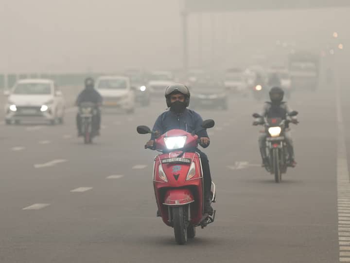 A man wearing a mask rides a two-wheeler amid hazy weather conditions, in New Delhi. (Source: PTI)