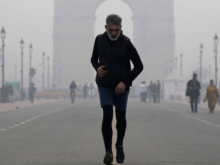 A man jogs along the Kartavya Path on Saturday even as dense smog shrouds the area. Pollution levels in Delhi and its surrounding areas dipped marginally overnight due to winds. However, the concentration of poisonous PM2.5 was still more than 80 times the upper limit and the AQI continues to remain in the 'severe' category. (Source: PTI)