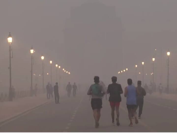 People jogging on the Kartavya Path amid dense smog near India Gate in Delhi. The air quality in the national capital continued to remain in the 'severe' category. (Source: ANI)