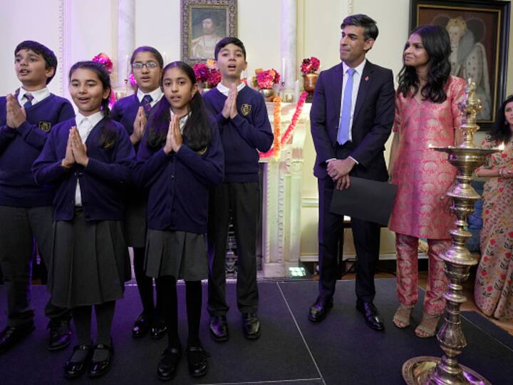 Rishi Sunak and his wife, Akshata Murty, listen as school children perform at the gathering hosted by them at 10 Downing Street. (Source: Getty)