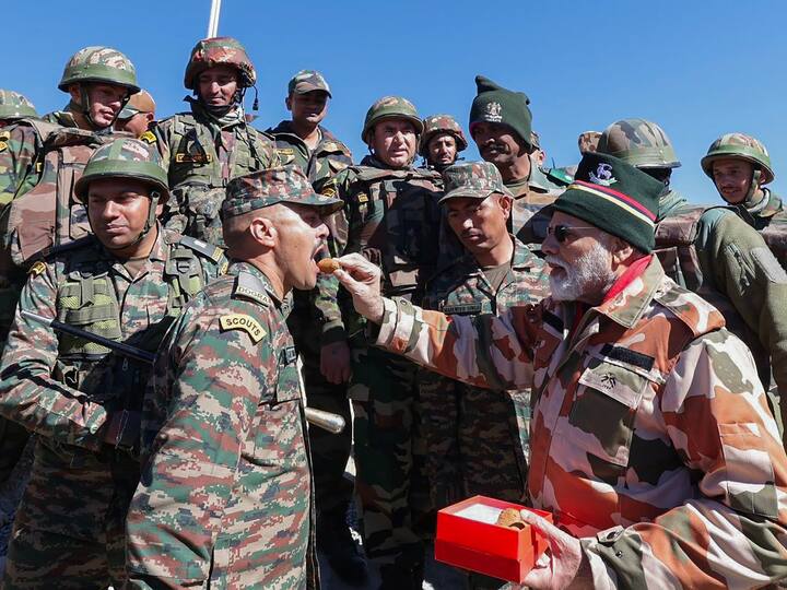 The Prime Minister gives an army man sweet as he celebrates Diwali with the troops. PM Modi has been celebrating the festival with soldiers for several years now. (Source: PTI)