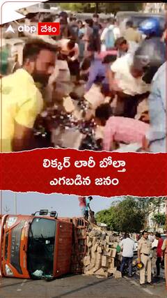 లిక్కర్ లారీ బోల్తా... సీసాలు ఎత్తుకెళ్లిన జనం