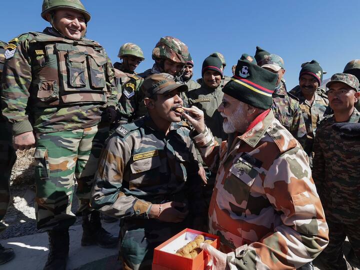 The Prime Minister gives sweet to a security personnel in Lepcha. He interacted with them and lauded their efforts. (Source: PTI)