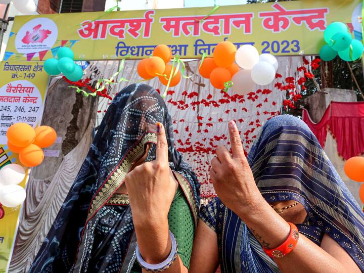 Women wearing veils (ghunghat) over their faces show their fingers marked with indelible ink after voting, in the outskirts of Bhopal. (Source: PTI)