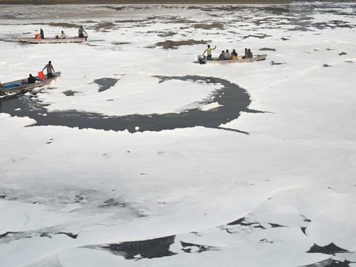Delhi authorities spray chemicals to dissolve toxic foam forming along the Yamuna River ahead of Chhath Puja at Kalindi Kunj Ghat in New Delhi. (Source: Getty)