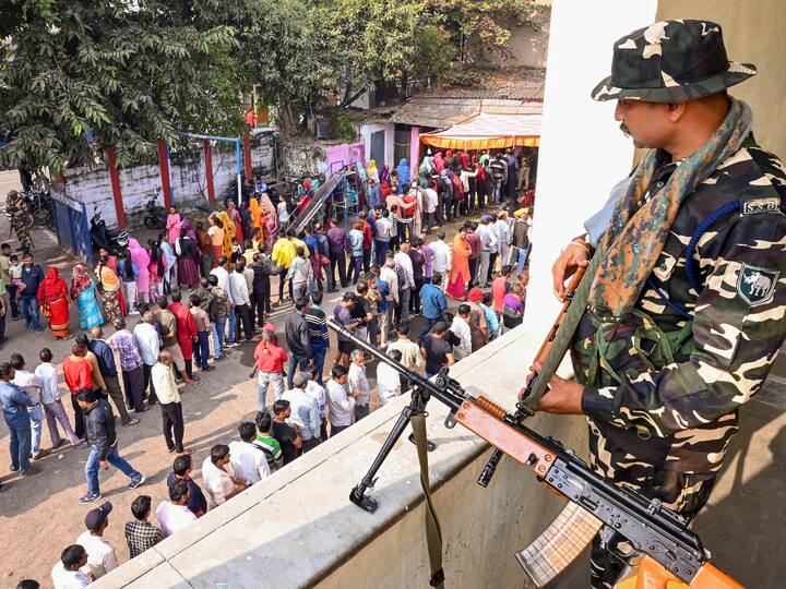 Security personnel keep watch on the voting procedure at a polling station in Jabalpur, MP. (Source: PTI)