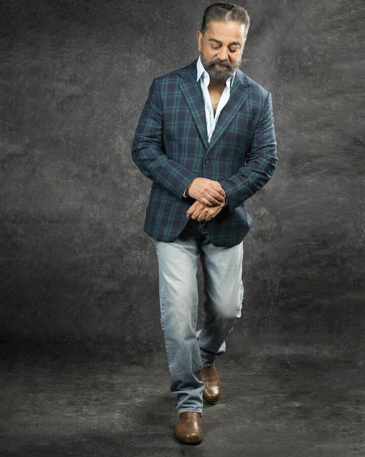 ஜீன்ஸ், ஃபார்மல் ஷூ, வெள்ளை சட்டை, கட்டம் போட்ட அடர் நீல நிற ப்ளேசர் அணிந்துள்ள கமல்
