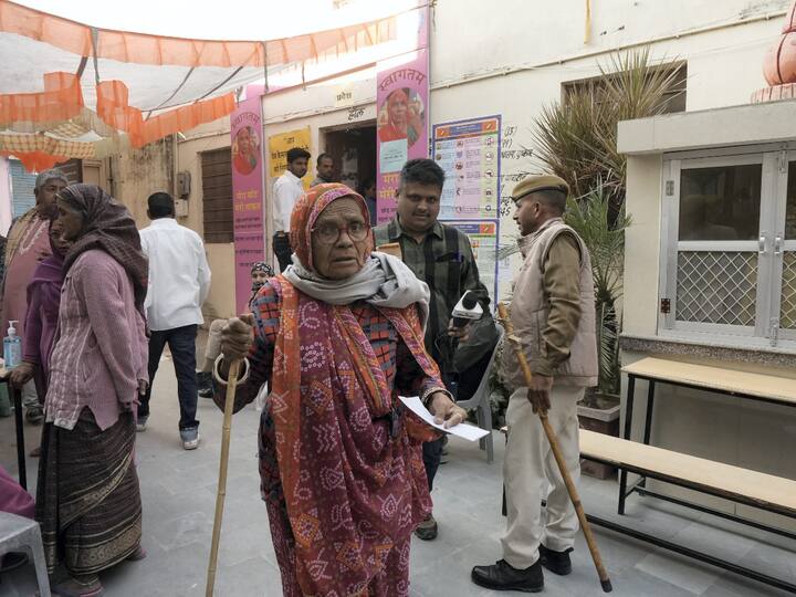 An elderly woman walks into a polling station in Pushkar to cast her vote for the Rajasthan Assembly election. (Source: PTI)