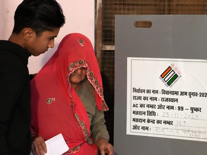An elderly woman helped by a young boy after she casts her vote during Rajasthan Assembly election in Pushkar. (Source: PTI)
