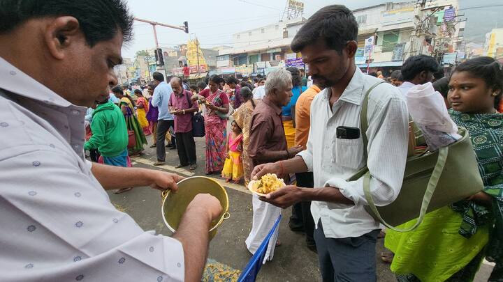 அன்னதான உணவை வாங்கும் பக்தர் ஒருவர்...