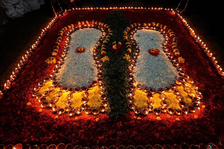 மலர்கள் மற்றும் விளக்குகளால் அலங்கரிக்கப்பட்ட பெருமாள் பாதங்கள்
