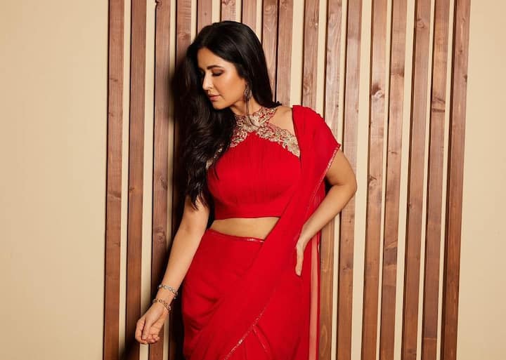 Katrina let her thick hair hang loose, allowing it to fall elegantly over her shoulder in delicate curls.