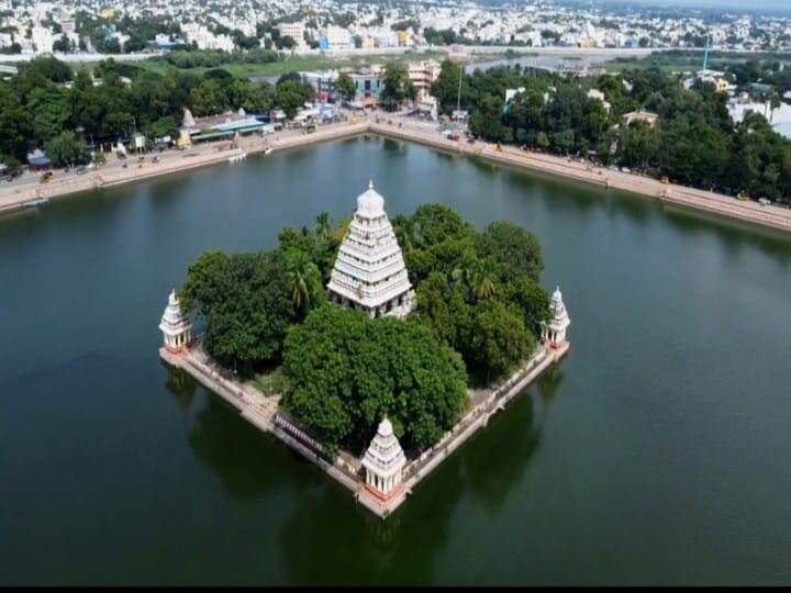 மரங்கள் சூழந்த மைய மண்டபத்தை கொண்ட தெப்பக்குளம்.