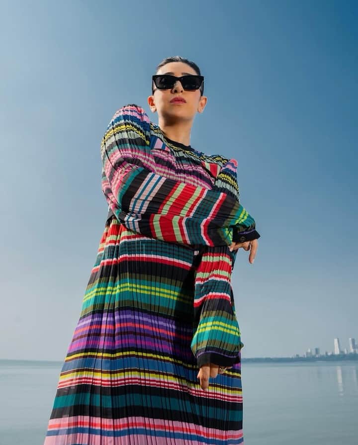 Karisma looks super cool with her hair tied in a bun and sporting black sunglasses.