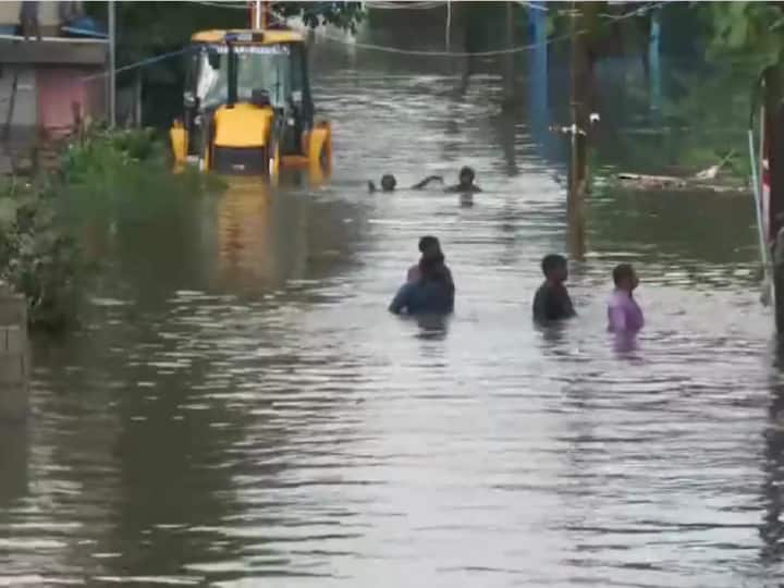 People wade through chest-deep waters in Pammal areas of Chennai as the city faces massive waterlogging on Tuesday following rainfall caused by Cyclone Michaung.(Source: ANI)