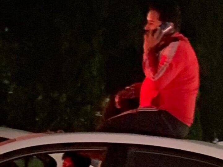 Gurugram Car Stunt man drank alcohol on moving car roof Police searching Accused after video viral ANN Gurugram Car Stunt: गुरुग्राम में चलती कार की छत पर युवक ने पी शराब, वीडियो वायरल होने के बाद तलाश शुरू