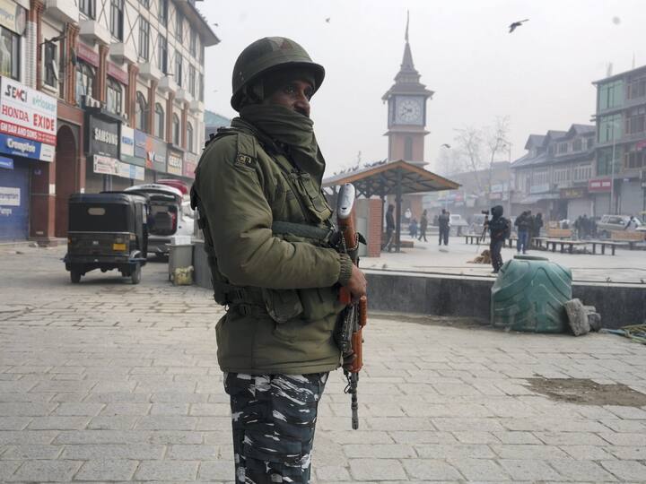 A security personnel stands guard at Srinagar's Lal Chowk after security was beefed up ahead of Supreme Court's ruling. Image Source: PTI