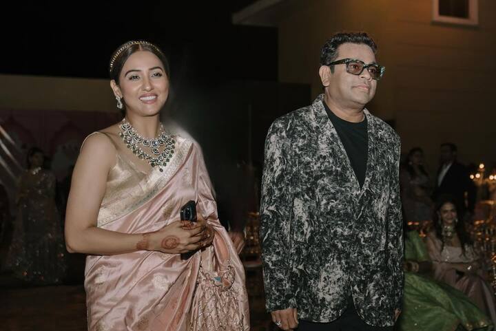 नीति मोहन ने रिसेप्शन पार्टी की कई तस्वीरें सोशल मीडिया पर शेयर की हैं. इस फोटो में वह एआर रहमान के साथ पोज देती हुईं नजर आ रही हैं.