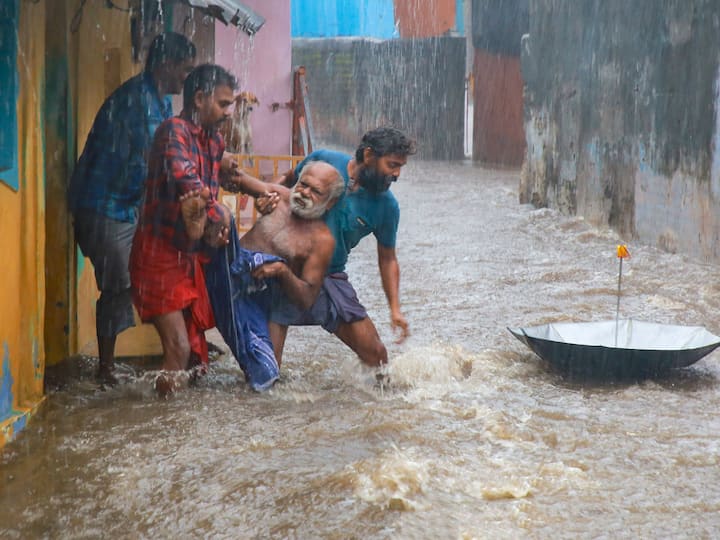 People are seen rescuing an elderly man from a heavily flooded area during heavy rain, in Kanyakumari district. (Image Source: PTI)