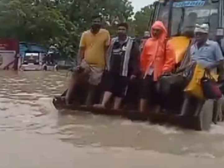 People were seen standing on an excavator to navigate through flooded roads in Thoothukudi, Tamil Nadu, after unprecedented rainfall. (Source: ANI)