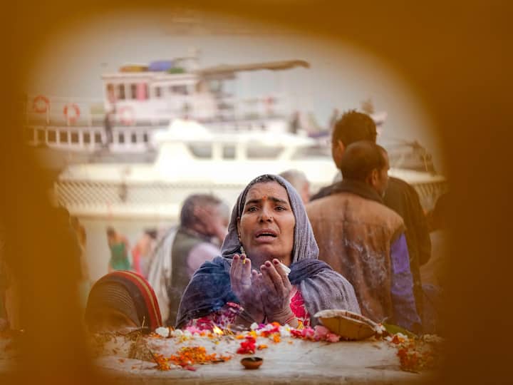 A Gangasagar Mela pilgrim offers prayers at a temple in Kolkata on the bank of the Ganga on her way to Sagar Island.