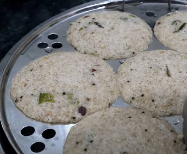 இட்லி தட்டில் எண்ணெய் தடவி, வறுத்த முந்திரியை வைத்து, ரவை கலவையை ஊற்றி இட்லி பாத்திரத்தில் வைத்து 15 நிமிடம் ஆவியில் வேகவைக்கவும்.