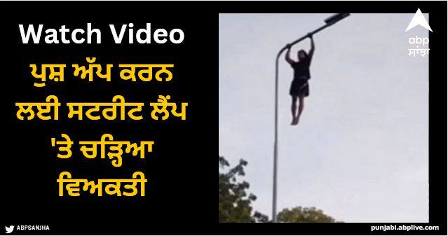 man climbed street lamp to do push ups video viral Viral Video: ਪੁਸ਼ ਅੱਪ ਕਰਨ ਲਈ ਸਟਰੀਟ ਲੈਂਪ 'ਤੇ ਚੜ੍ਹਿਆ ਵਿਅਕਤੀ, ਵੀਡੀਓ ਦੇਖ ਲੋਕਾਂ ਨੇ ਫੜਿਆ ਸਿਰ