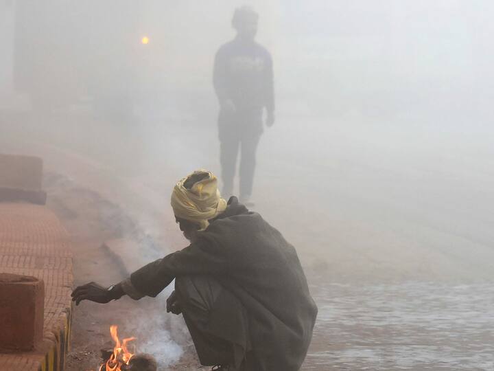 A man warms himself with a bonfire during a cold and foggy winter morning, in Patna. (Photo: PTI)